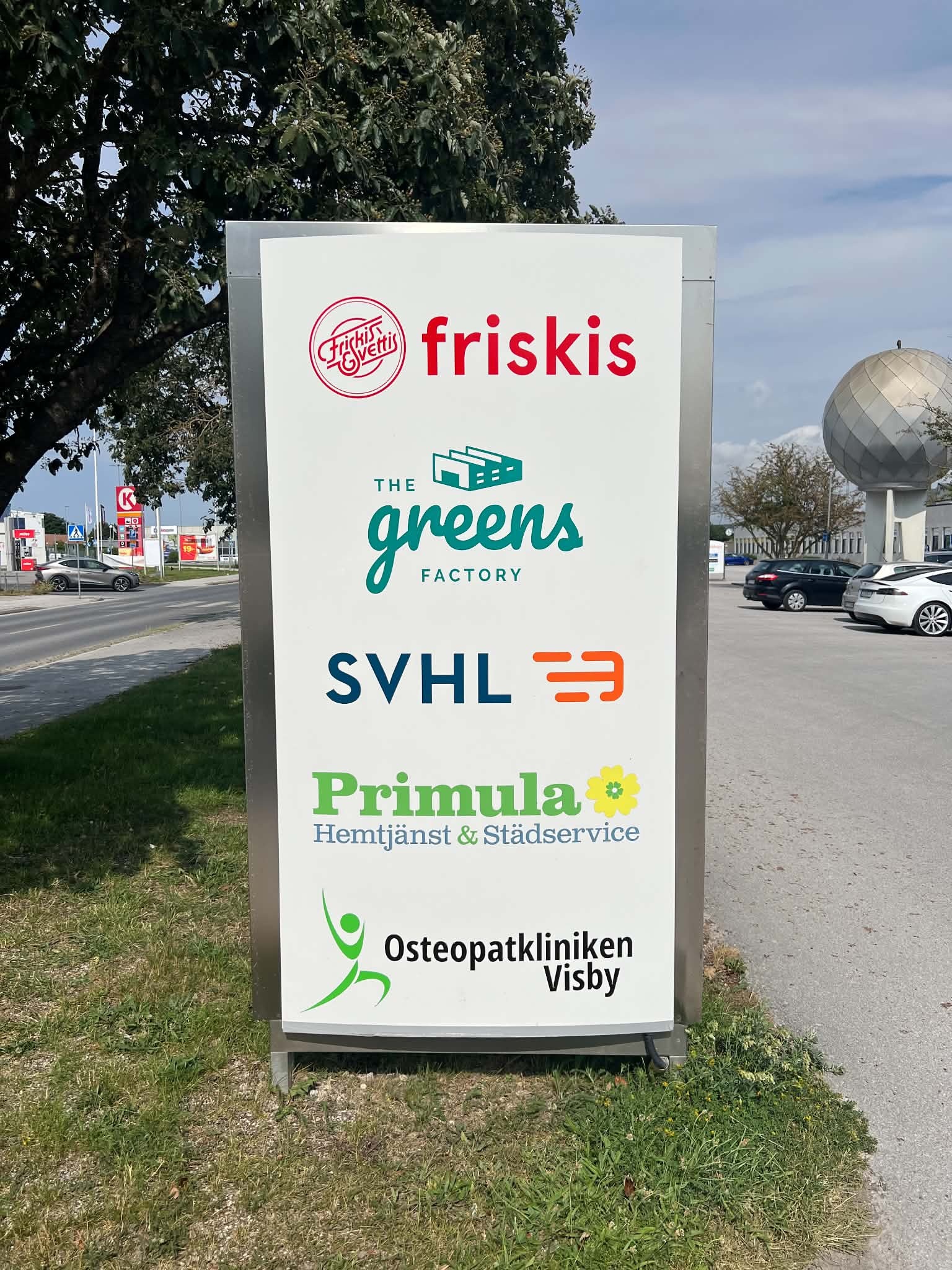 Skylt vid vägen till Osteopatkliniken Visby tillsammans med andra verksamheter